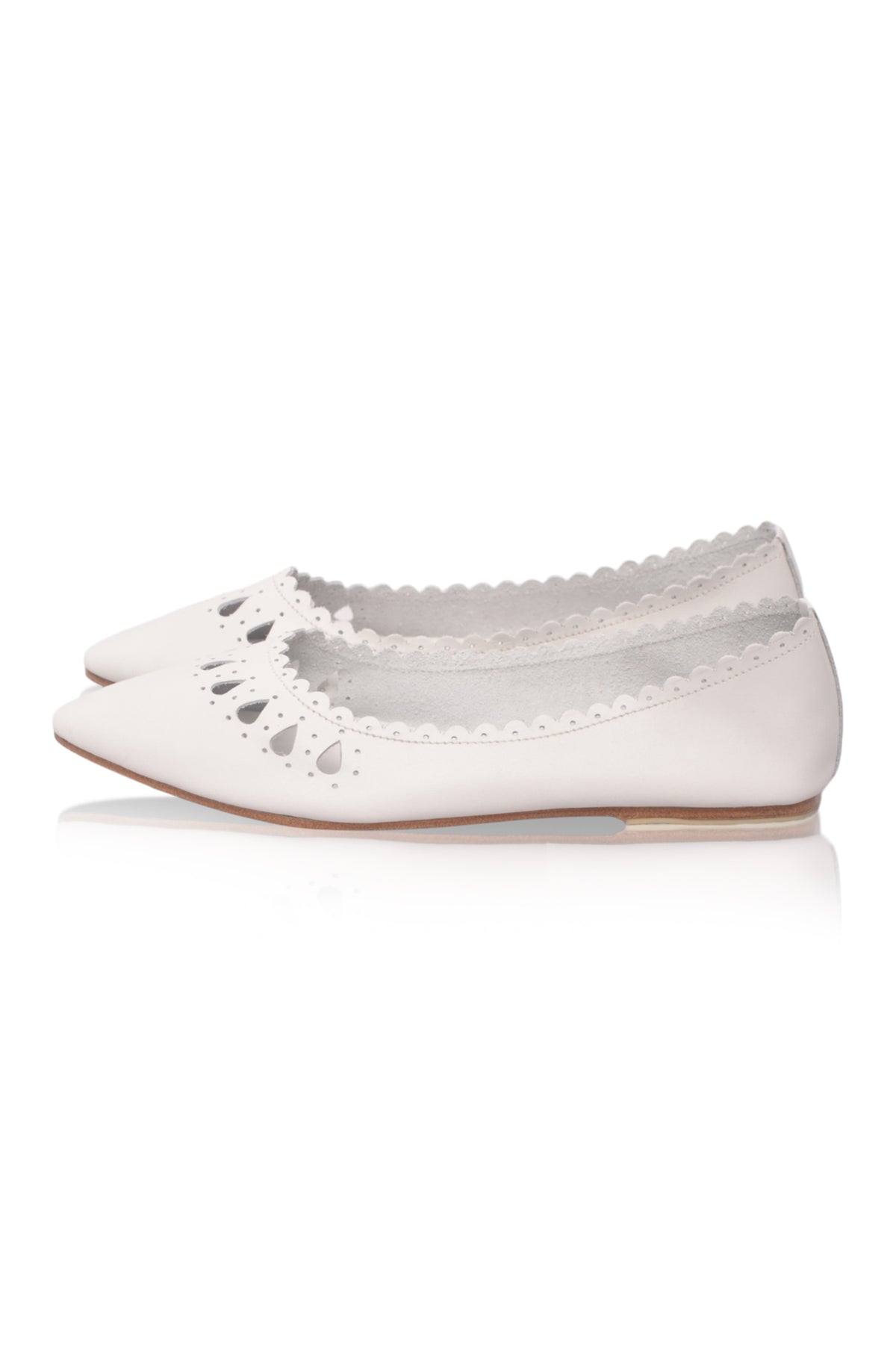 A pair of white pointed-toe flats with scalloped cutout detailing along the vamp, shown against a plain white background.