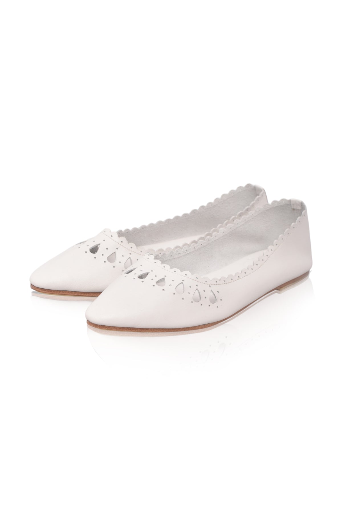 A pair of white pointed-toe flats with scalloped edges and laser-cutout detailing on the toe, shown on a clean white background.