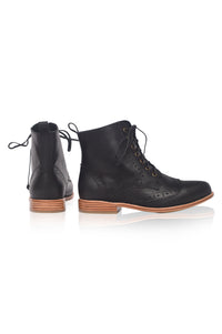 Black leather boots with brown soles on a white background