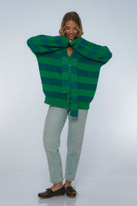 Person wearing a green and blue striped sweater on a white background