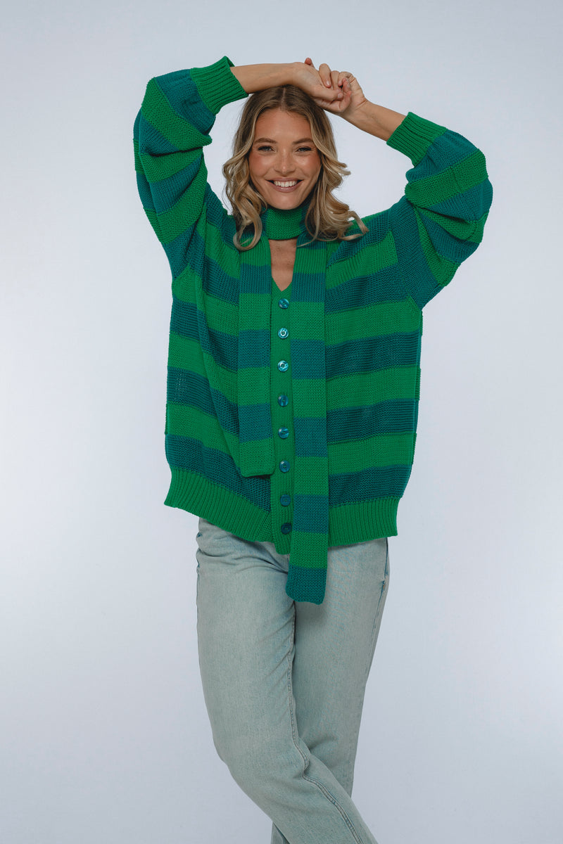Woman wearing a green and blue striped sweater on a white background