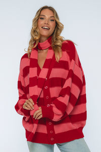 Woman wearing a red and pink checkered cardigan on a white background