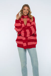 Woman wearing a red and pink checkered cardigan on a white background