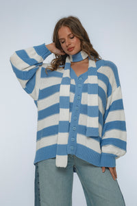 Woman wearing a blue and white striped sweater against a plain background