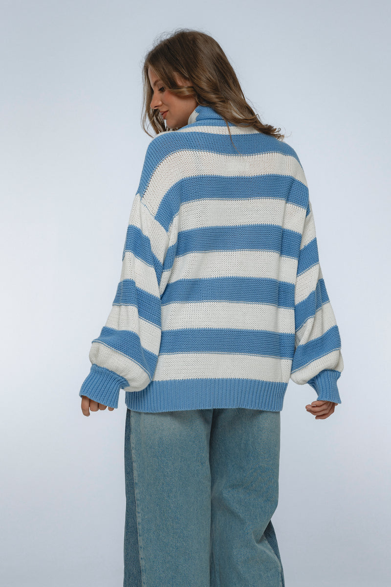 Person wearing a blue and white striped sweater against a plain background