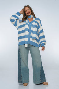 Woman wearing a blue and white striped sweater and light blue jeans on a white background