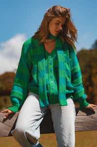 Woman wearing a green plaid cardigan outdoors with a blurred natural background