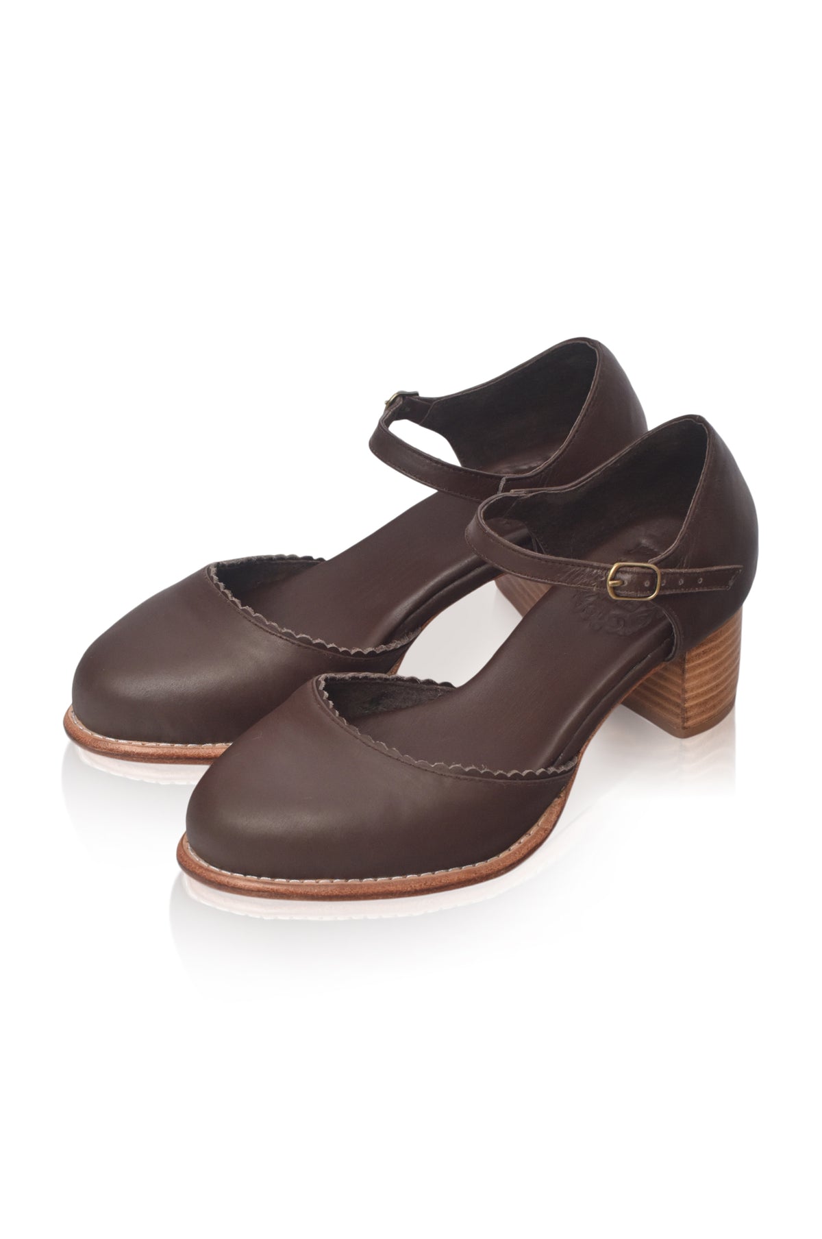 A pair of dark brown leather Mary Jane-style block heel shoes with ankle straps and a small gold-tone buckle, displayed on a clean white background.