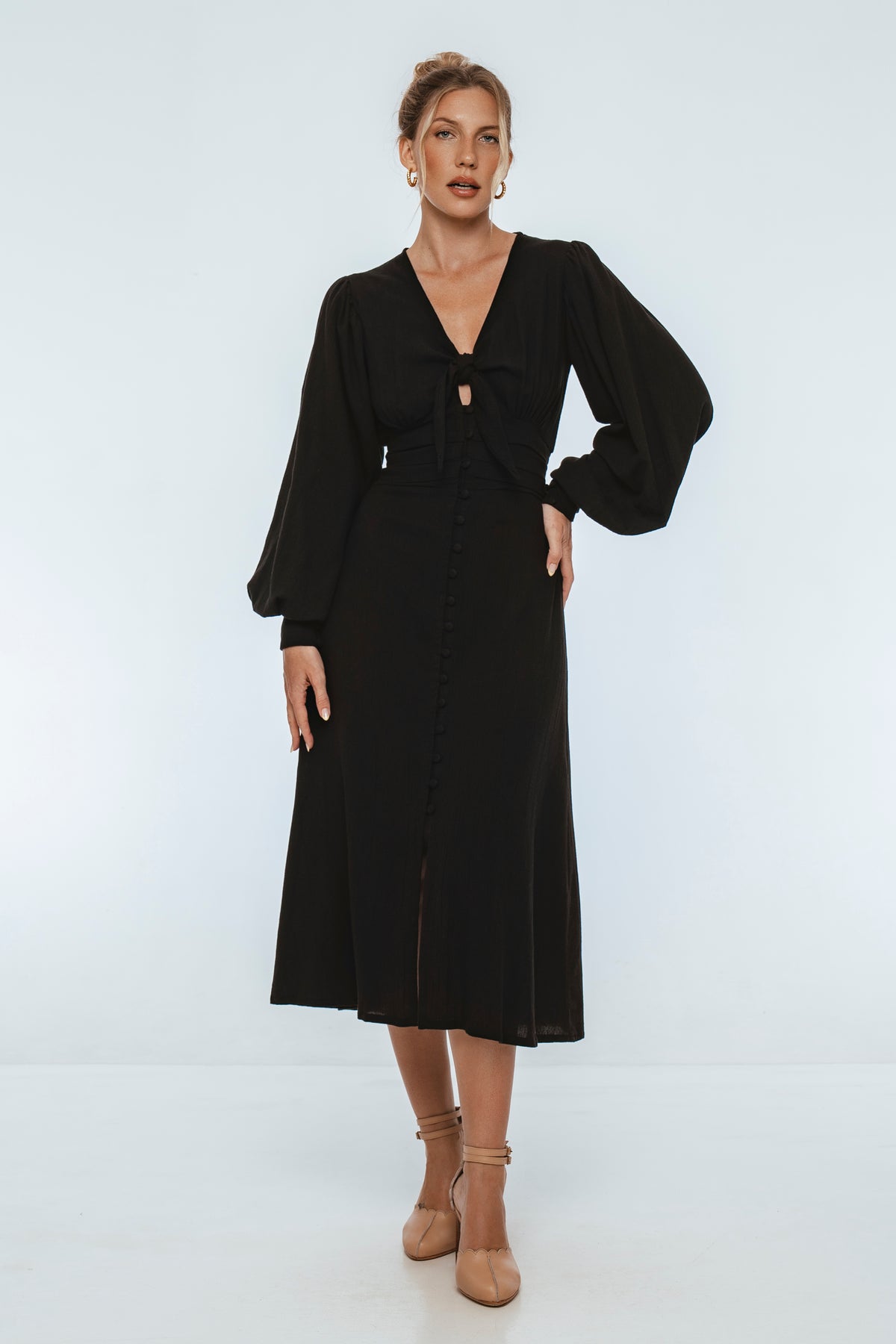 Woman wearing a black dress against a white background
