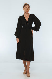 Woman wearing a black dress against a white background