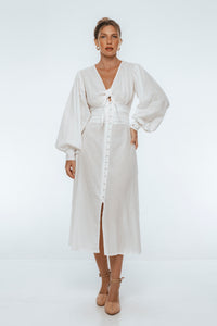 Woman wearing a white dress with long sleeves on a white background