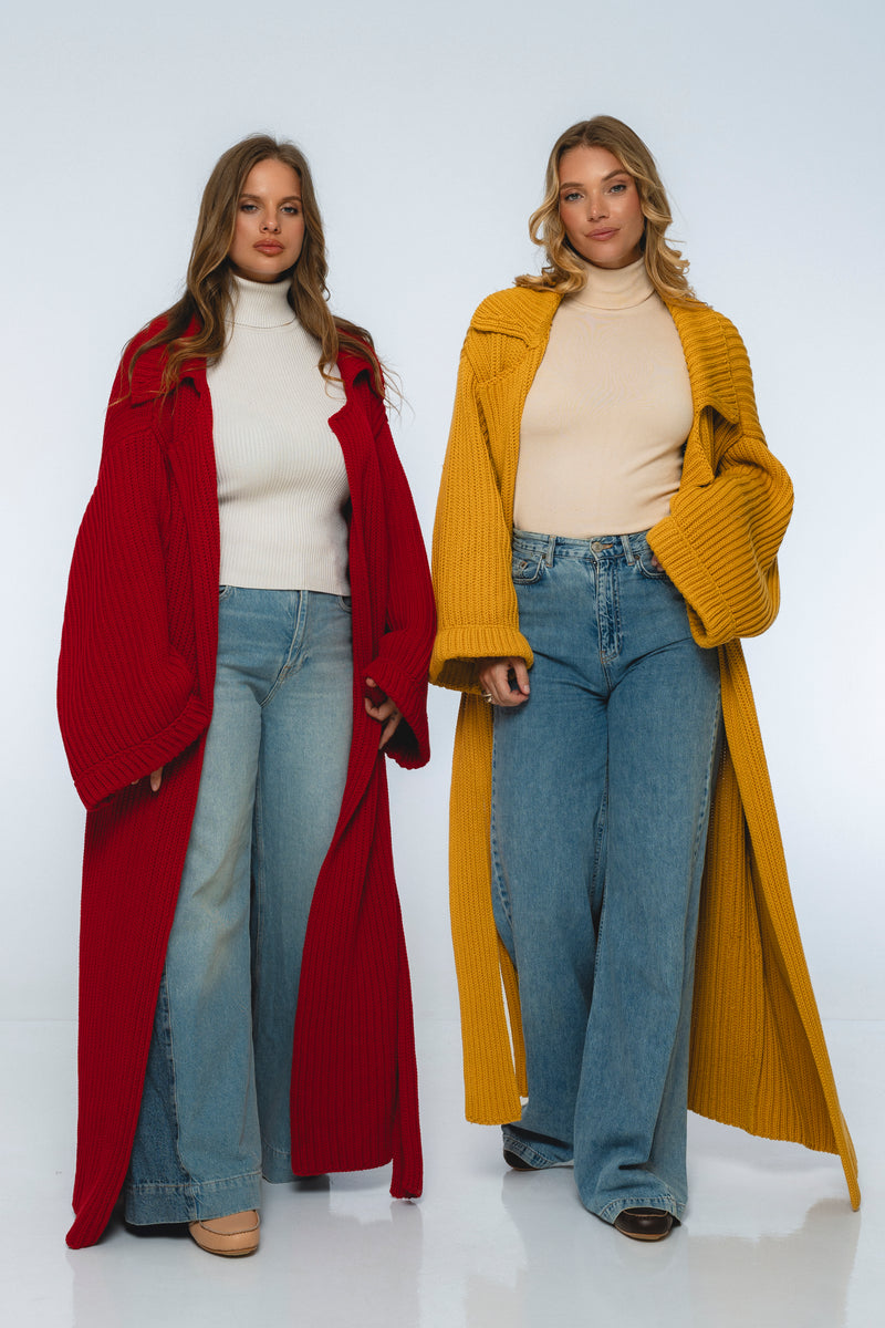 Two women wearing long coats, one red and one yellow, standing against a white background.