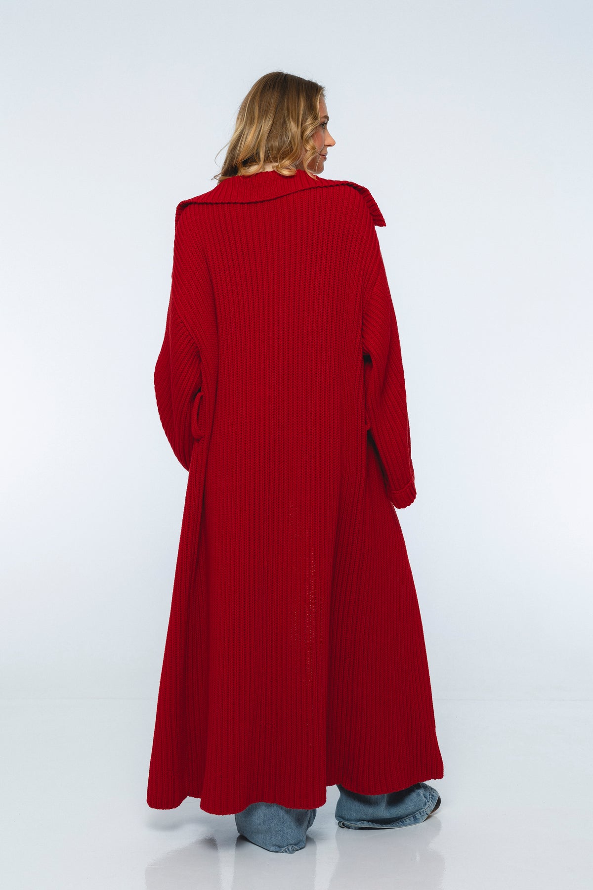 Person wearing a long red coat on a white background