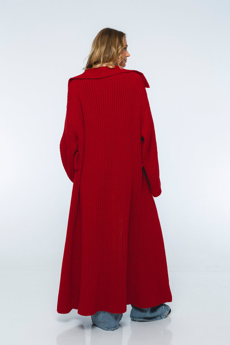 Person wearing a long red coat on a white background