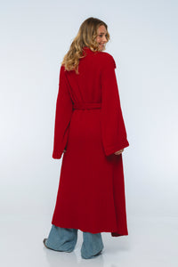 Person wearing a long red coat on a white background