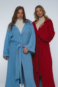 Two women wearing long, ribbed knit robes in blue and red on a white background.