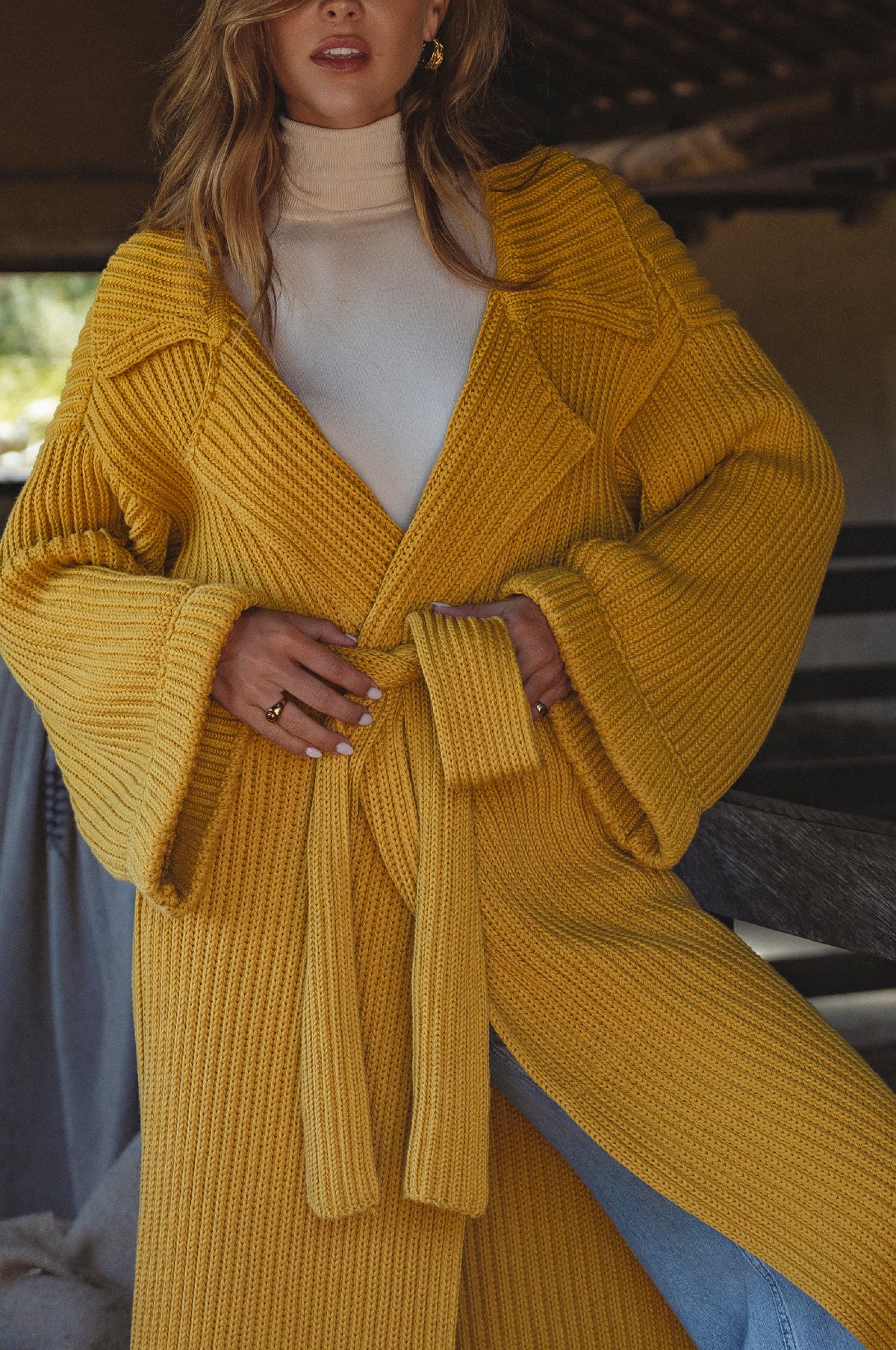 Woman wearing a yellow knitted coat with belt