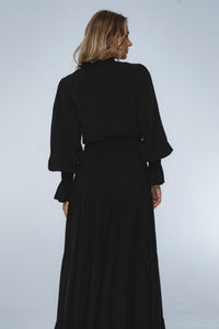 Woman wearing a long black dress against a white background