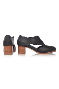 Black leather shoes with wooden block heels on a white background