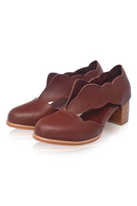 Pair of brown leather shoes with wooden heel on a white background