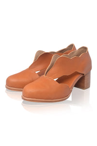 Pair of brown leather shoes with wooden block heels on a white background
