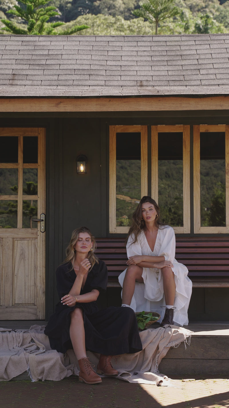 Video of models wearing handmade linen dresses in midi length and v-neckline. Dresses in black and white linen