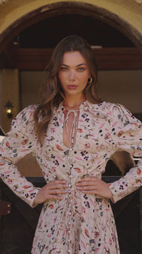 Video of a model wearing dress in cream floral printo